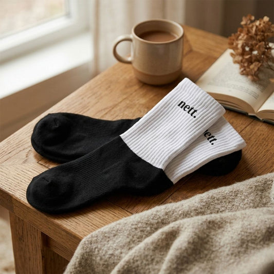 ein paar Socken mit dem Statement nett aufgedruckt auf einem Tisch liegend